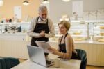 Senior male barista teaching his daughter business
